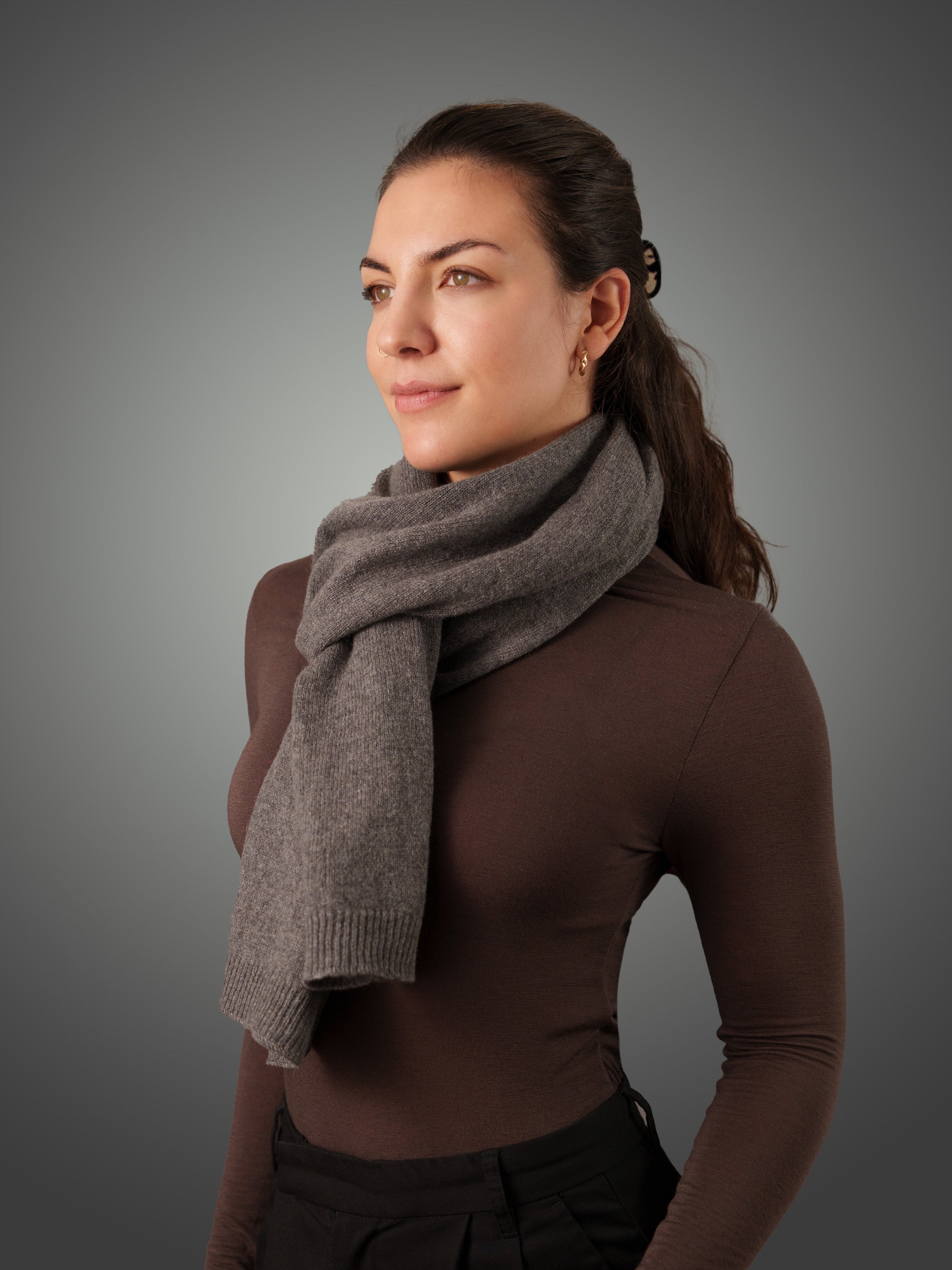 Woman wearing a gray cashmere scarf against a gray background