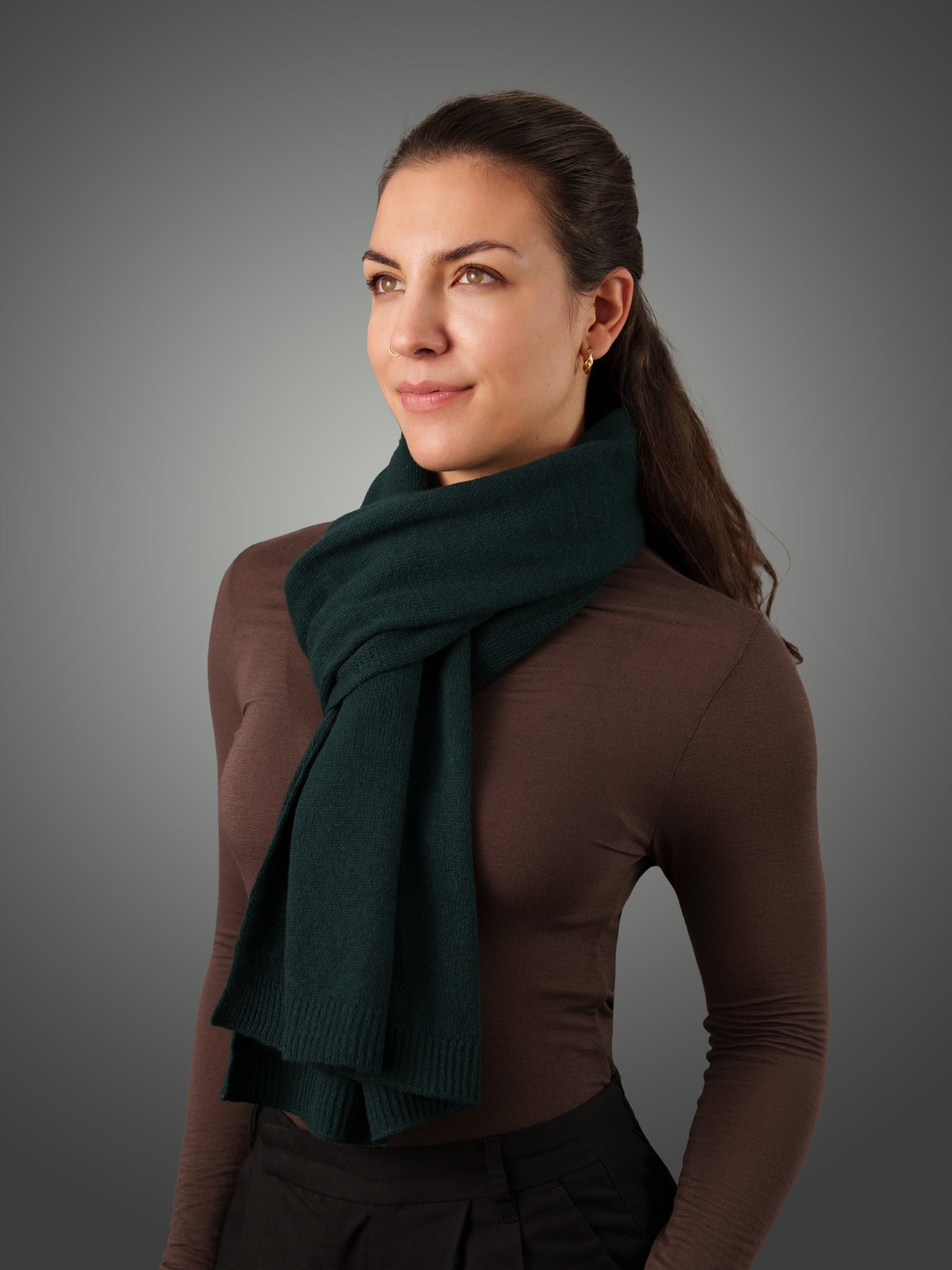 Woman wearing a green cashmere scarf with gray background